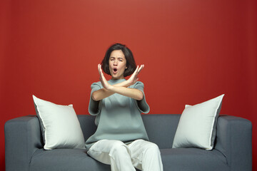 Angry outraged young girl rejecting offer or communication, does refusing or stop gesture, sitting...