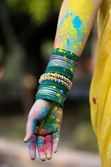 Holi dry organic color or colour or gulal or abeer or Holi powder on hand of a woman girl lady wearing bangles celebrating festival of color holi