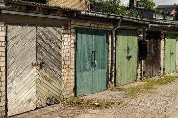 Fototapeta na wymiar Wooden garage doors of different colors, Ventspils, Latvia.