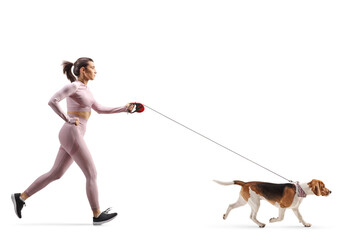 Full profile shot of a female in crop top and leggings running with a beagle dog on a leash