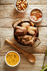 Fototapeta premium Homemade fritada a typical ecuadorian dish that consists on braised pork. It’s served on a white plate with chilli and tostado, with a traditional and wooden background 