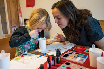 Mother and daughter making epoxy jewelry at home.