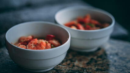 Shrimp soup with red pepper in white bowls