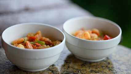 Shrimp soup with red pepper in white bowls