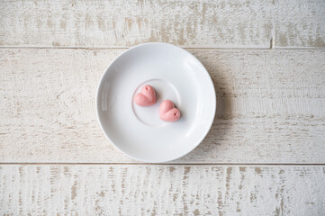 Fototapeta na wymiar White pink composition with saucher and chocolates