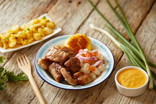 Homemade fritada a typical ecuadorian dish that consists on braised pork. It&rsquo;s served on a white plate with motepillo and with a traditional and wooden background 