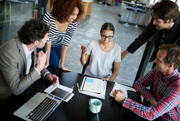 leading her team to success. Shot of office workers talking in a meeting in an office.
