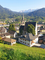Obraz premium View of the city Fiera di Primiero with houses and a church. Vertical.