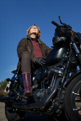 Mature woman with a leather jacket in a black motorbike enjoying the moment