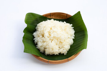 Sticky rice on banana leaf in bamboo basket on white background.