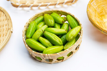 Bilimbi fruit in bamboo basket on white background.