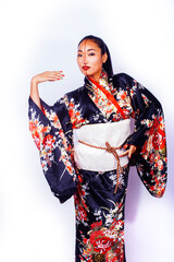 young pretty geisha in black kimono posing isolated on white background, asian ethno