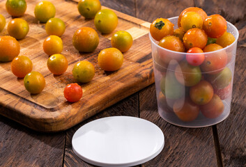 Fresh cherry tomatoes inside a plastic container - Space for text