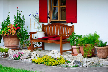 drewniana, brązowa ławka w ogrodzie pod oknem, sitting area in the garden, wooden garden bench	 - obrazy, fototapety, plakaty