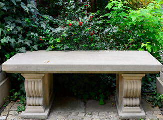 kamienna, rzeźbiona ławka w ogrodzie, krzew Ilex z czerownymi owocami, relaxation area in the garden, stone garden bench