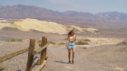 Fototapeta na wymiar Young pretty woman exploring remains of industrial workings at the old Harmony Borax mine works in Death Valley National Park, California, USA.