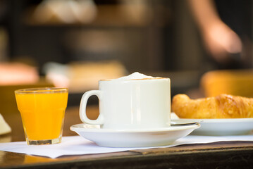 coffee with milk, orange juice and croissants