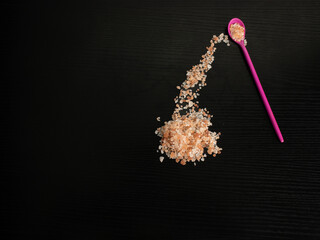 Himalayan pink salt, with fuchsia teaspoon and black background