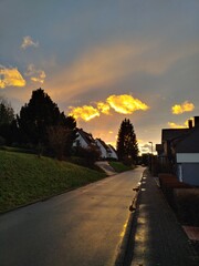 Dramatic and vibrant orange sky at sunset on a stormy winter day in Siegerland (vertical), Dahlbruch, NRW, Germany
