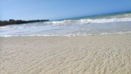 Beach sand closeup with waves on the background