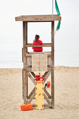 Baywatch sitting on watchtower in beach