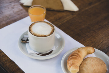 coffee with milk, orange juice and croissants
