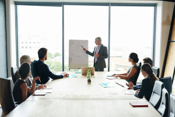 Getting everyone on board with the project. Shot of a group of executives having a meeting in a boardroom.