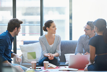 Her time to shine. Shot of a group of office workers talking together in a meeting room.