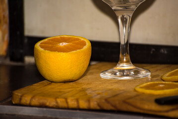 person placing orange slices in a glass