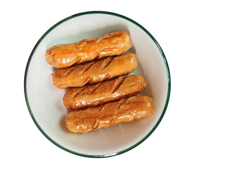 Four fried sausages in a white plate on a white background, top view.