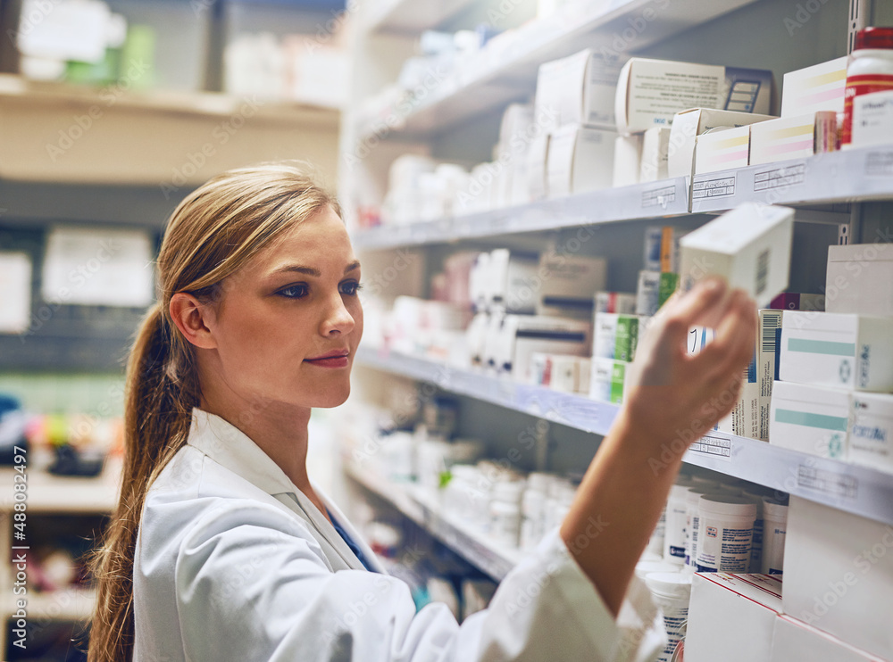 Wall mural I know exactly the medication thatll help you. Shot of a pharmacist looking at medication on a shelf.