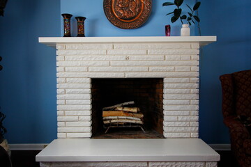 A white fireplace against blue walls