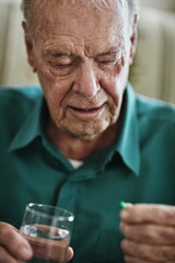Managing his chronic condition to stay healthy. Cropped shot of a senior man about to take his medication.