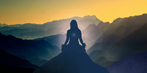woman silhouette in meditation position against a mountain landscape with copy space for your text