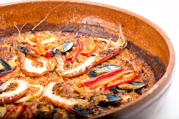 baked seafood with vegetables in a clay plate. Mussels and shrimps.