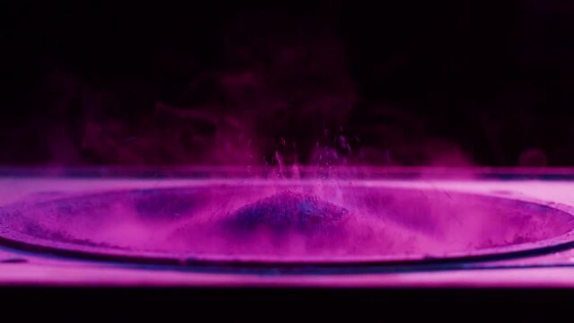Subwoofer with pink paint powder. Bass speaker, loud music volume macro shooting. Professional disco studio equipment. Playback of musical stereo system, vibration, acoustic sound.