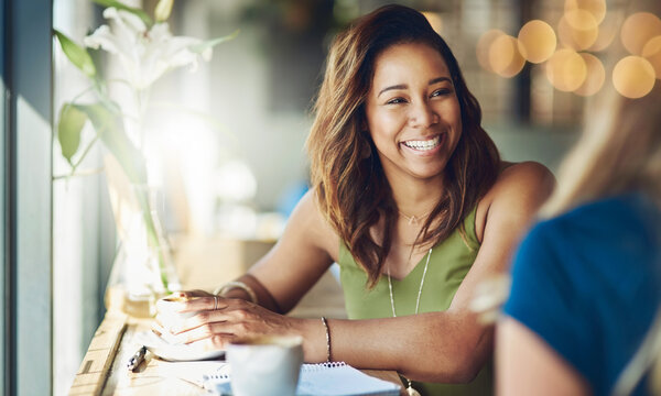 I believe this is the only way to chill. Cropped shot of a woman chatting to her friend in a cafe.
