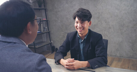 Two businessmen talking together at office desk, business meeting room with happiness and make high five for good news. High five Two partner executive young man meeting team solidarity power concept