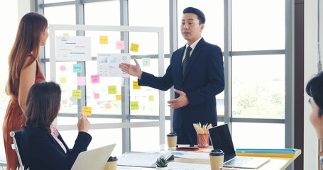 Happy business people meeting present graph chart investment, business data in meeting room. Group of business people meeting in conference room. Asian businessman speech, present teamwork partnership