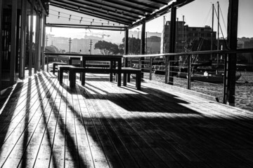 A beautiful grayscale of an abandoned empty wooden place with metal fence outdoors