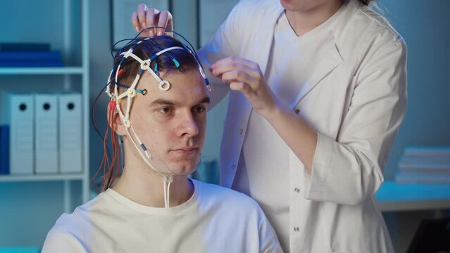 EEG topographer for examining brain, doctor making electrogram of scalp activity. Researching of brain work man wearing electroencephalography headset. 