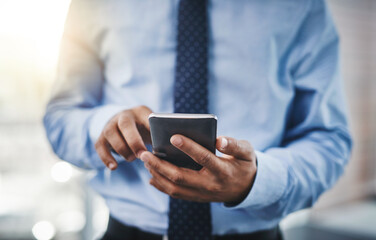 Success depends on the moves you make. Cropped shot of an unrecognizable businessman using his phone in the office.