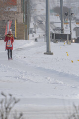 Woman walking on snow covered street in winter