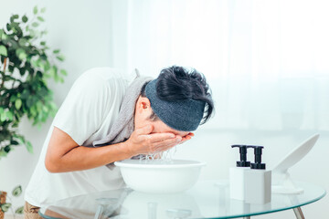 水で洗顔する男性
