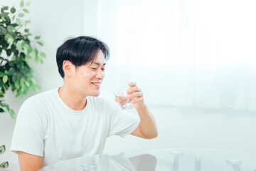 水・白湯を飲む男性（笑顔）
