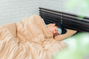風邪をひいてベッドで寝る男性
