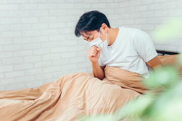 ベッドで休む体調不良の男性（咳）
