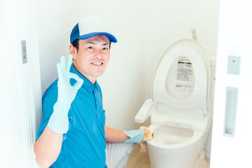 トイレの掃除をする作業着の男性
