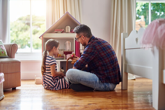 Giving Her Dolls A Place To Call Home. Shot Of A Little Girl Playing With A Dollhouse At Home.