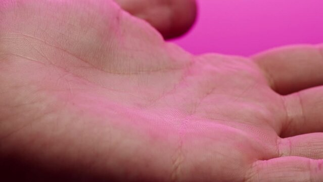 Hand skin in pink neon light, female human body part and ultraviolet, arm surface macro shooting.